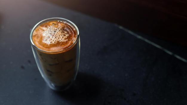 Café helado en una mesa con crema que se vierte mostrando la textura