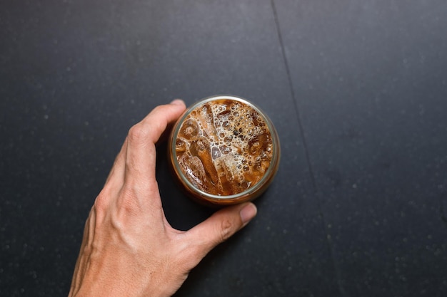 Café helado en una mesa con crema que se vierte mostrando la textura