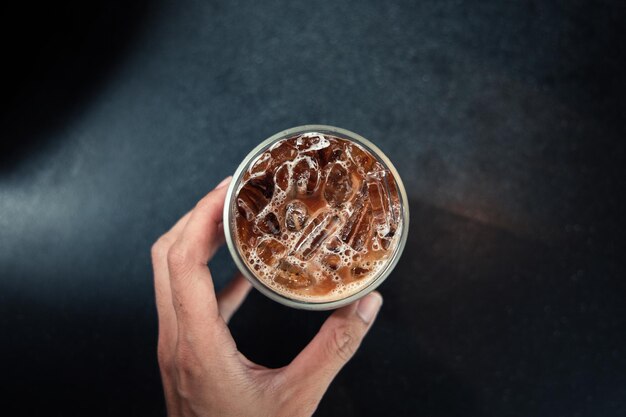 Café helado en una mesa con crema que se vierte mostrando la textura