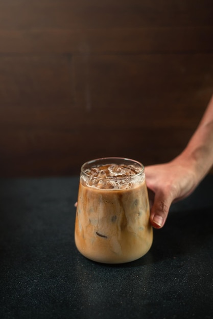 Café helado en una mesa con crema que se vierte mostrando la textura