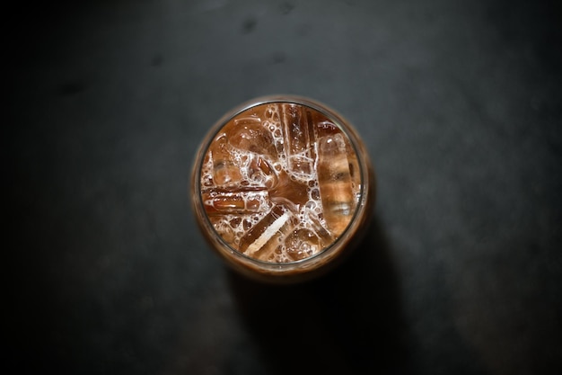 Café helado en una mesa con crema que se vierte mostrando la textura