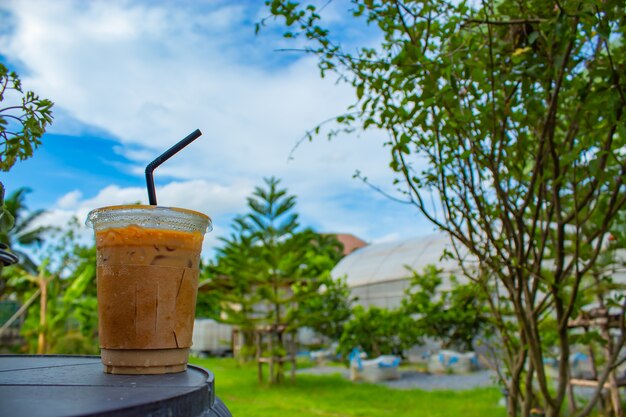 Café helado en una mesa de madera en el jardín.