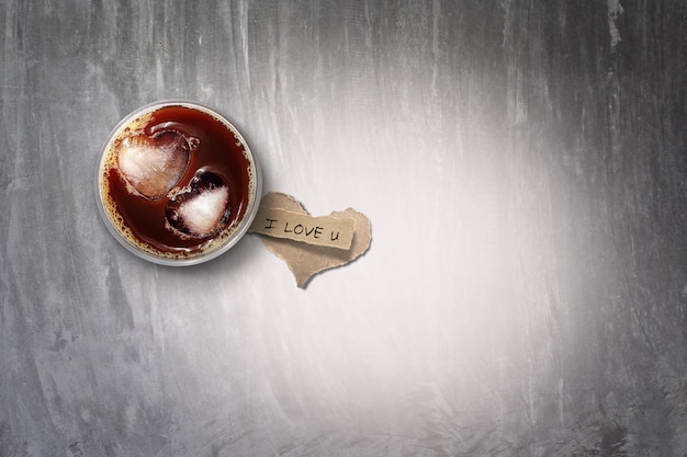 Café helado y papel rasgado en el piso de concreto, en tonos de color. para el dia de san valentin