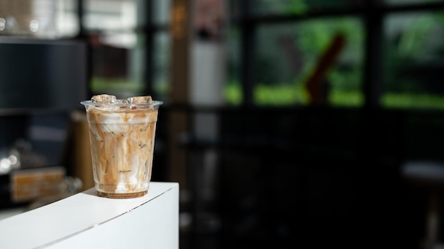 Café helado en taza de plástico en la mesa de la cafetería