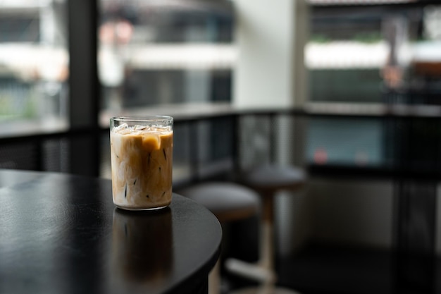 Foto café helado en vaso en la mesa en la cafetería fondo borroso