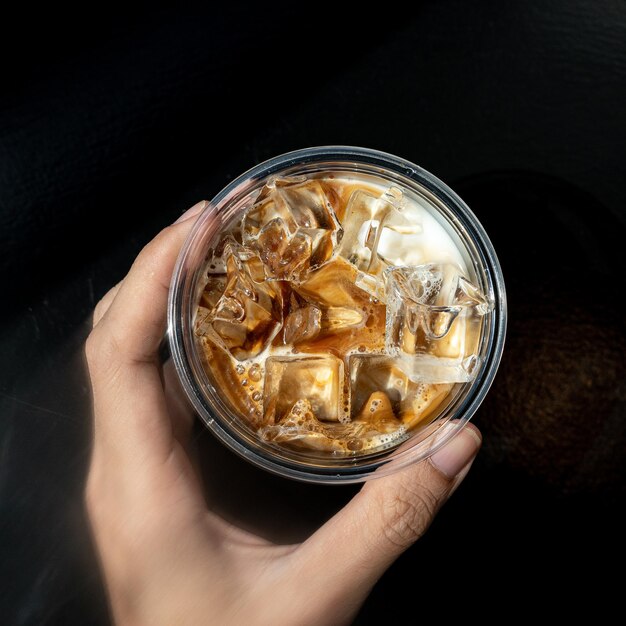 Café helado en vaso en la mesa en la cafetería fondo borroso