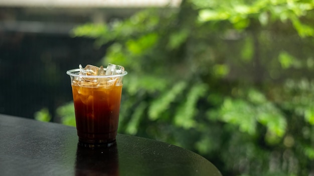 Café helado en vaso en la mesa en la cafetería fondo borroso