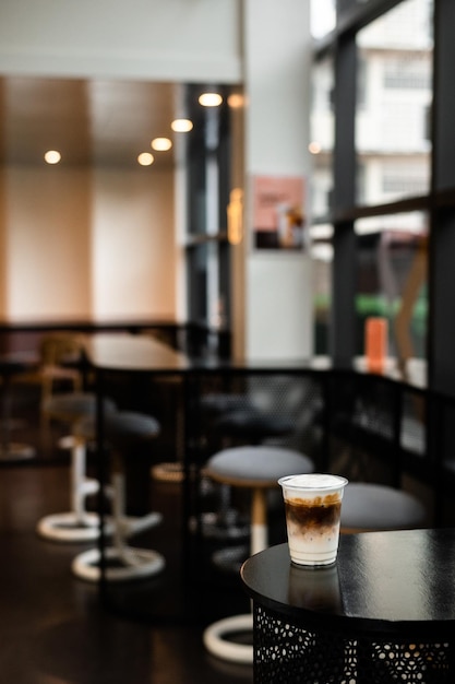 café helado en vaso de plástico sobre una mesa negra en el café