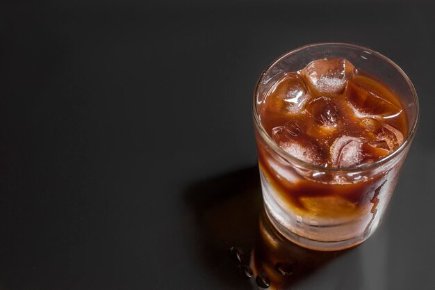 Café helado en un vaso sobre fondo negro Refresco frío bebida de verano