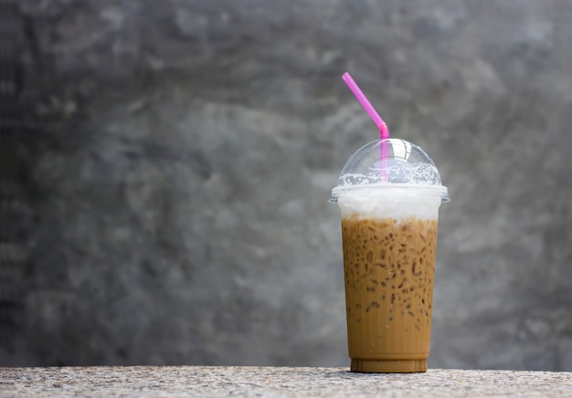 Café con hielo en la mesa y fondo de piedra