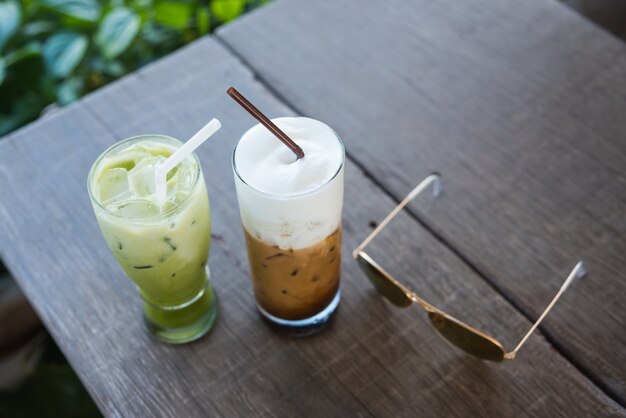 Café de hielo y té verde en el fondo de madera del verde de la tabla