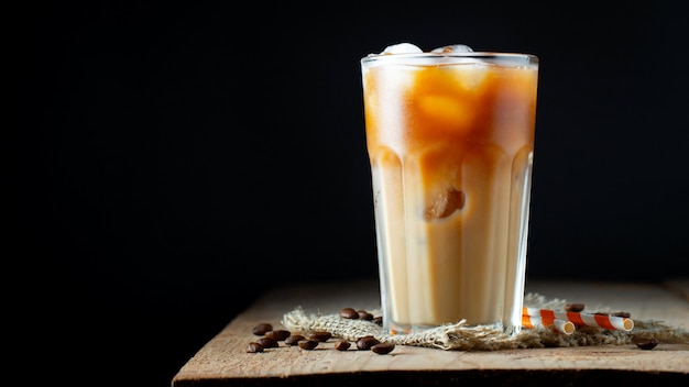 El café con hielo en un vaso alto con crema se vierte sobre.