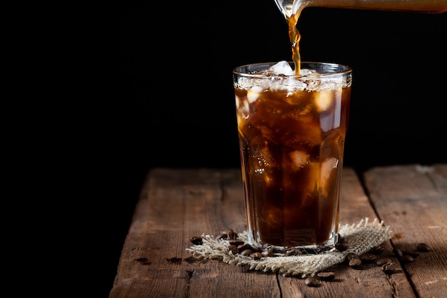 Café con hielo en un vaso alto con crema.