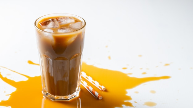 Café con hielo en un vaso alto con crema.