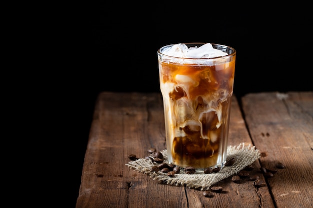 Café con hielo en un vaso alto con crema.