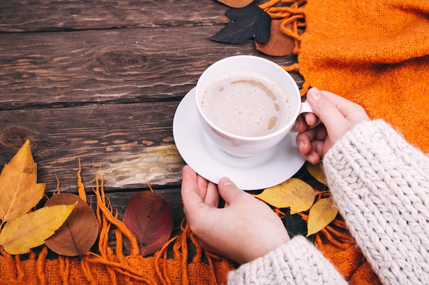 café y hojas de otoño sobre un fondo de madera