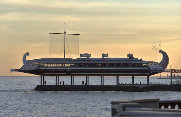 Café in Form eines stilisierten ägyptischen Bootes am Abend an der Uferpromenade der Hauptstadt Jaltathe