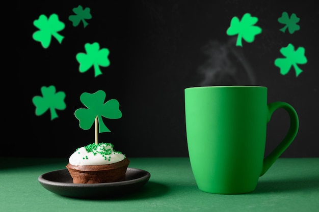 Café irlandês em xícara verde e cupcakes especiais para o dia de são patrício