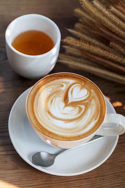 Café latte art con té sobre fondo de madera