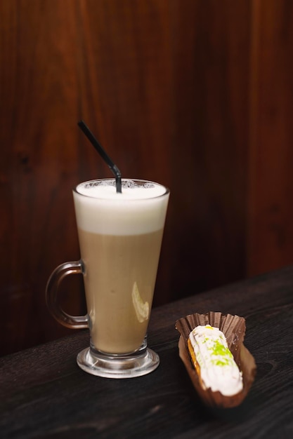 Foto café latte com chocolate cheesecake em uma cafeteria em uma mesa de madeira