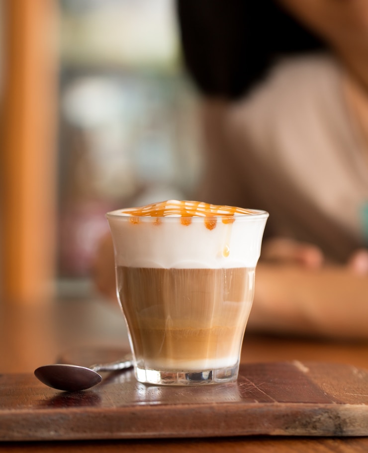 Foto café latte macchiato en el mostrador de madera en la cafetería