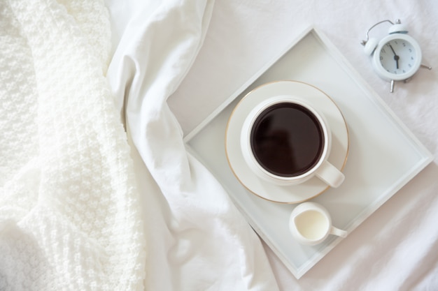 Café con leche en una bandeja en la cama