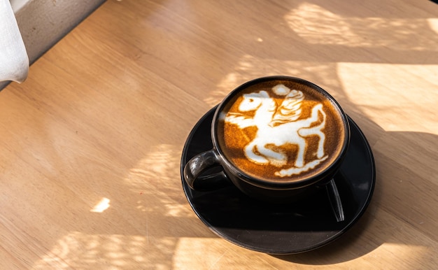 Café con leche caliente con arte de café con leche en forma de espuma de leche de caballo en una taza en un escritorio de madera en la vista superior Como desayuno En una cafetería en el concepto de trabajo de negocios durante la cafetería