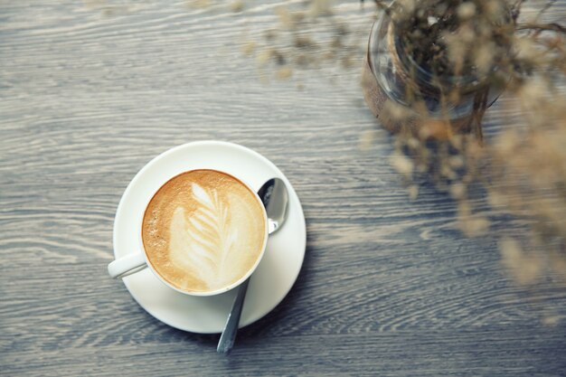 Café con leche caliente sobre fondo de madera