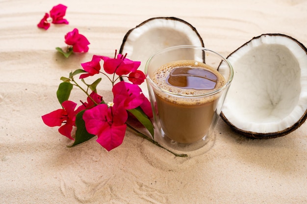 café con leche con coco en la playa de arena.