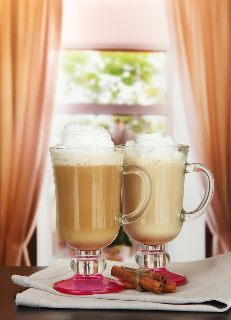 Foto café con leche fragante en vasos con vainas de vainilla en la mesa del café