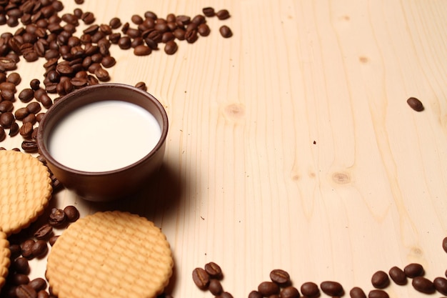 Foto café, leche y galletas en la mesa.