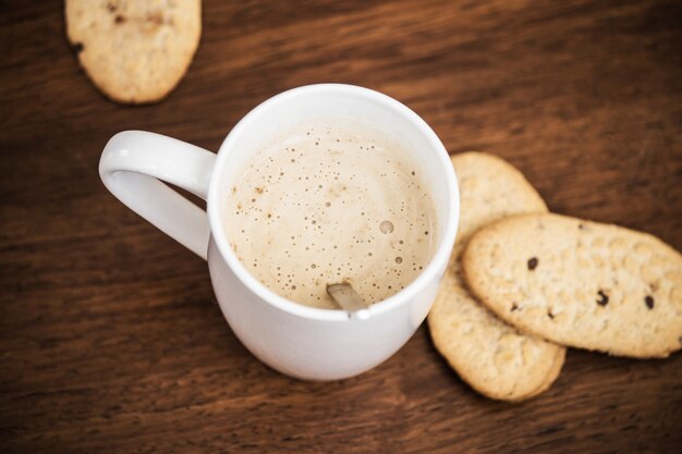 Café con leche y galletas con taza blanca y el texto me gustas un café con leche