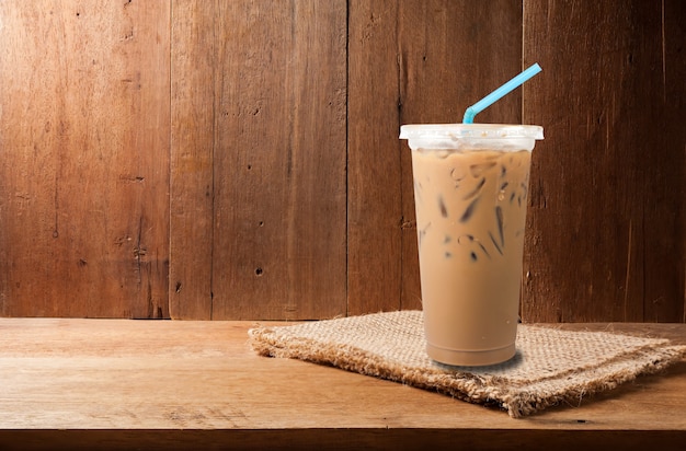Café con leche helada y café en grano en el espacio vacío copia de madera