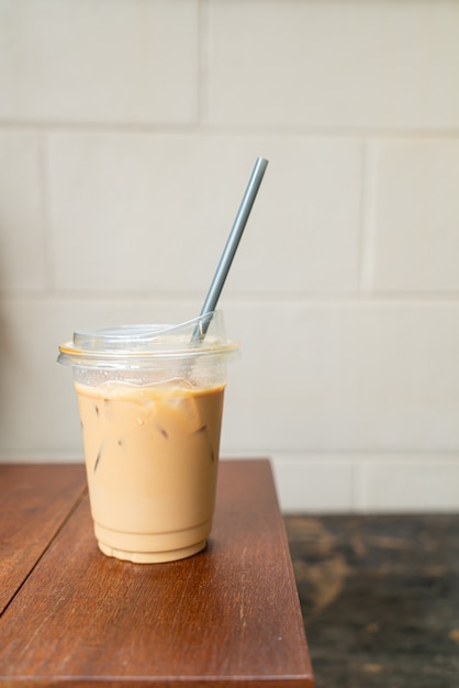 Café con leche en madera de vidrio para llevar en la mesa