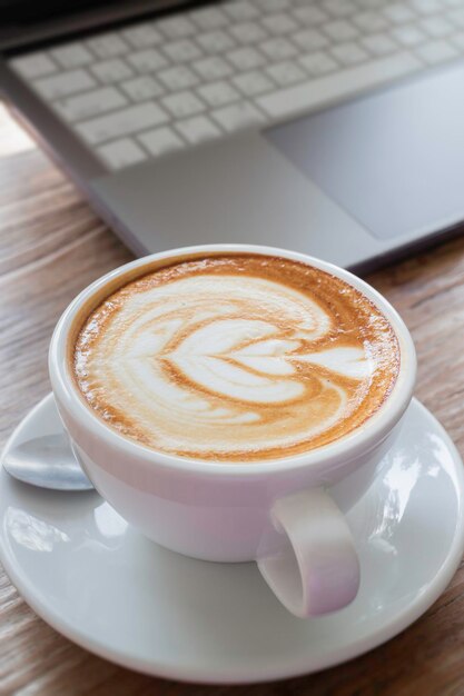 Café con leche por la mañana en un escritorio de madera trabajando desde la oficina de casa