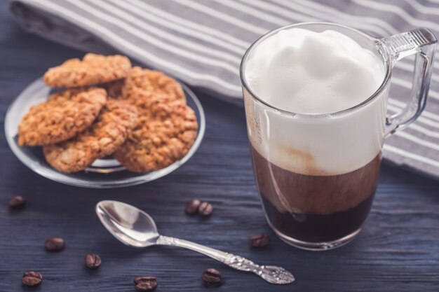 Café con leche en la mesa de madera. Foto tonificada