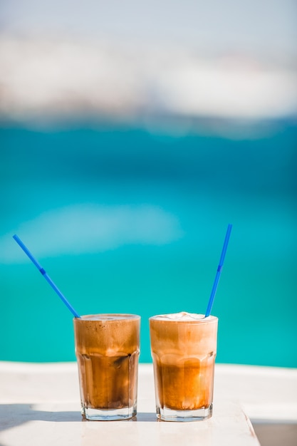 Café con leche en la mesa de madera con mar