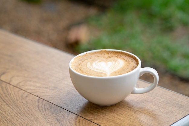 Café con leche o café capuchino en taza blanca con arte latte