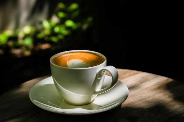 Foto café con leche en pisos de madera con poca luz luz natural para diseño o trabajo de fondo