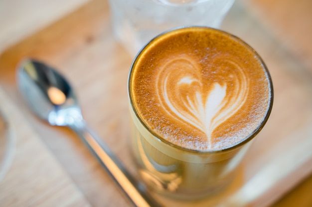 Café con leche servido con un vaso de agua