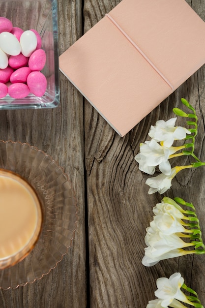 Café, livro, flores e ovos de páscoa na mesa de madeira