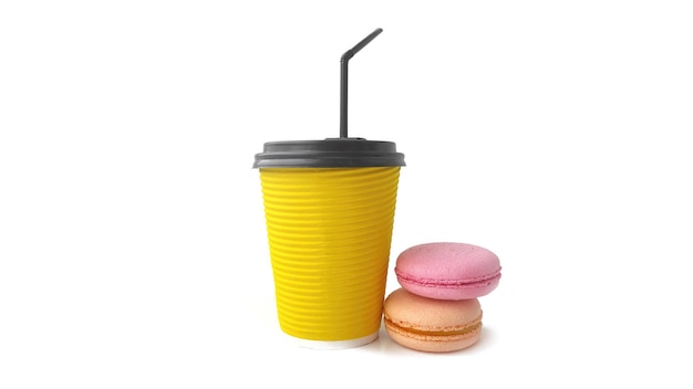 Café para llevar concepto Una taza de café o té amarillo desechable con deliciosos pasteles de macarrón franceses