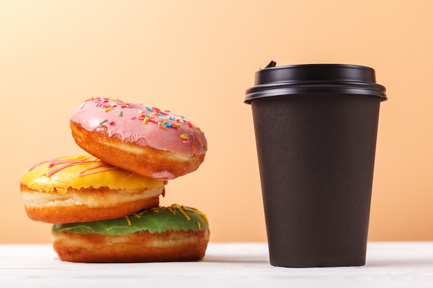 Café para llevar y donas, un bocadillo rápido en el camino. Concepto de servir comida para llevar para una cafetería o panadería.