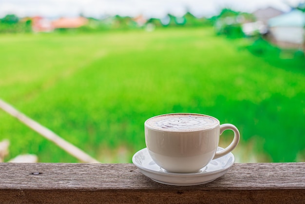 Café en una mesa de madera en un fondo natural en un jardín de colores cálidos