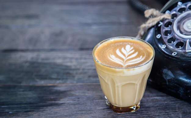 café en la mesa de madera con teléfono viejo