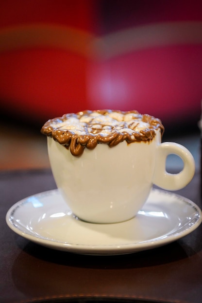 Café Mocha em uma mesa de café com foco seletivo e fundo desfocado de tons vermelhos