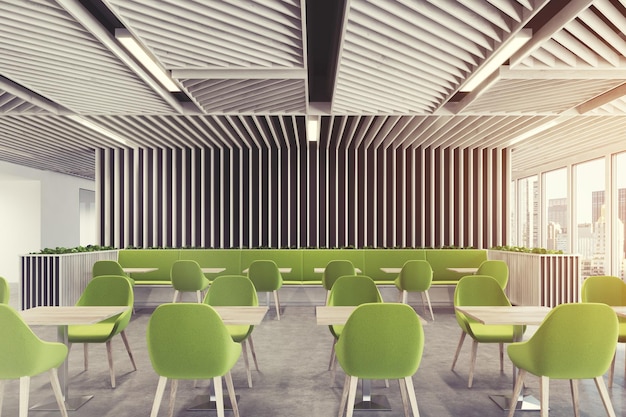 Café moderno o interior de una cafetería con paredes de madera ligera, ventanas panorámicas y sillones verdes cerca de mesas de madera cuadradas.