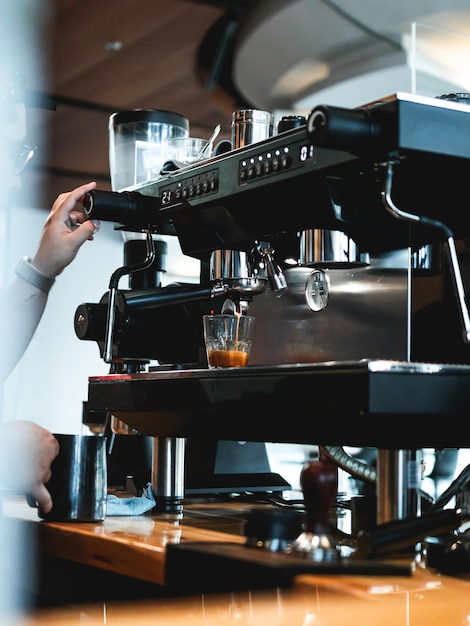 Café moderno servicio de máquina de espresso negra con taza de cristal llena de café