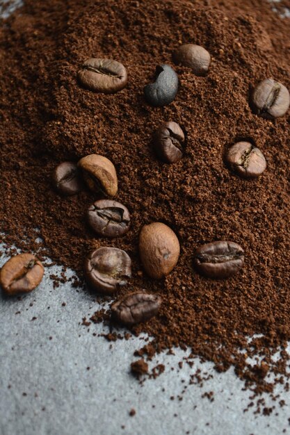 El café molido mezclado con frijoles está esparcido sobre la mesa.