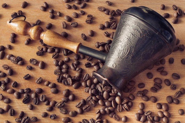 Café natural, aromático, não moído do tsezh derramado sobre uma superfície de madeira